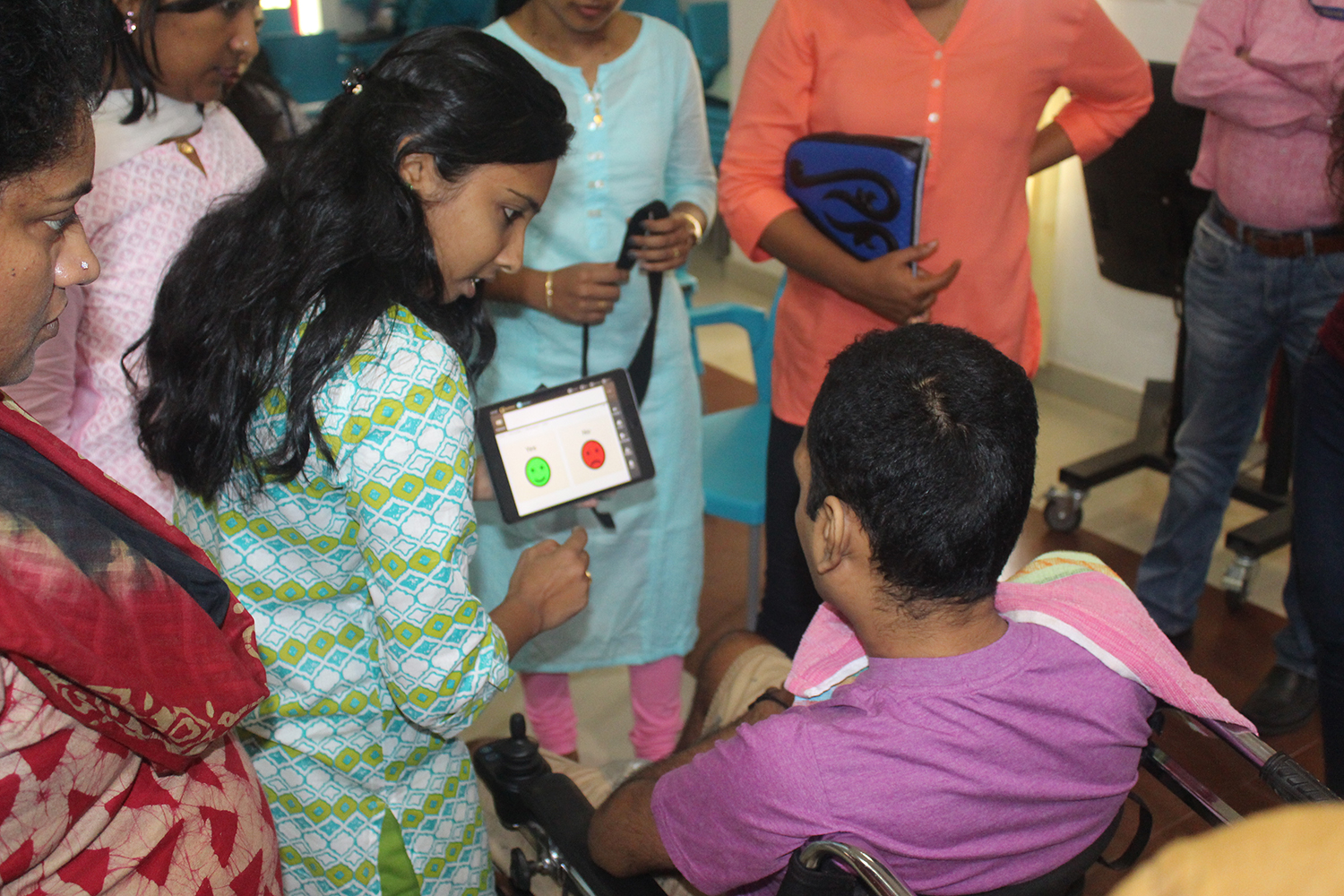 An image of a woman showing a tablet that has asks about an assistive technology